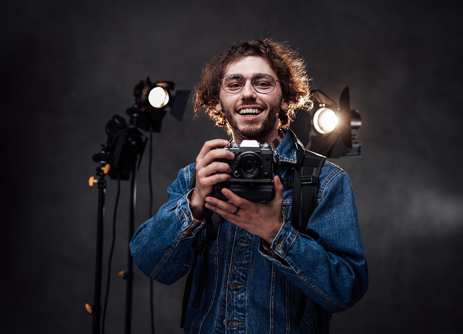 young-photographer-holds-a-camera-studio-portrait-resize.jpg